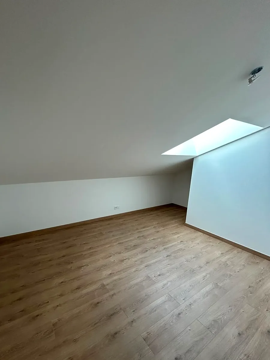 Combles aménagés et finis, plafond peint, parquet posé sous le velux